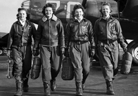Image of four female pilots with an airplane behind them