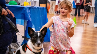 child pets a dog at Open House