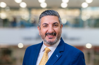 Professor Farzan Sasangohar, wearing a blue blazer and yellow tie and smiling