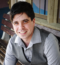 Professor Corey Schimpf, wearing a grey vest and collared shirt and smiling
