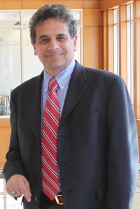 Professor Shiva Raman, wearing a red tie and blazer