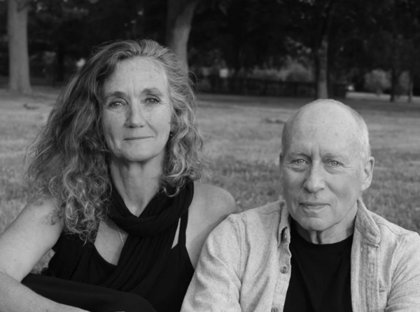 Black and white photo of a grown woman and a grown man standing side by side.