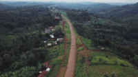 Long dirt road on a green landscape full of trees