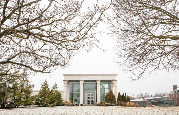 snowy 2-story glass entrance to museum with white columns