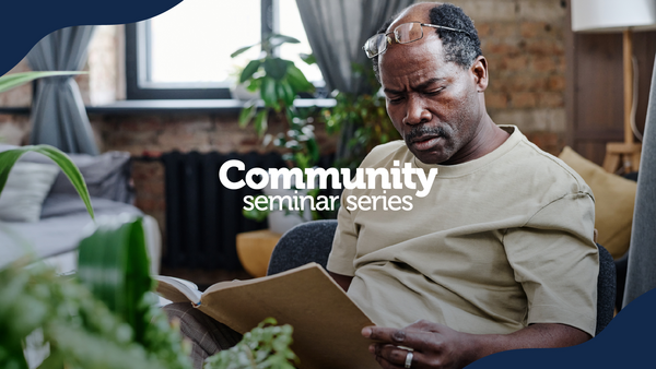 Community Seminar Series. A man sitting in a chair and reading a book.