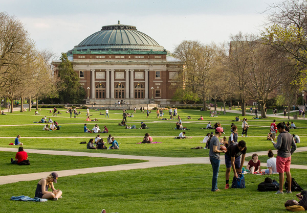 Foellinger Auditorium on a spring day. The main quad is filled with students engaged in various activities.