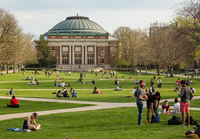 Foellinger Auditorium on a spring day. The main quad is filled with students engaged in various activities.