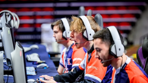 Three esports players at computer monitors