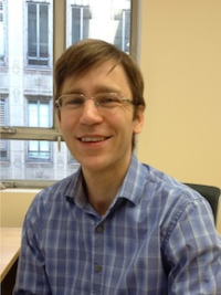 Image of Dr. Joel McManus. He is smiling and has short sandy brown hair and wire-frame glasses.