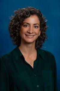 Dr. Lici Schurig Briccio. Person with dark curly hair