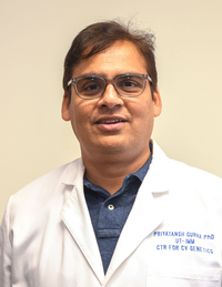 Dr. Priyatansh Gurha. Person with dark hair and glasses wearing lab coat
